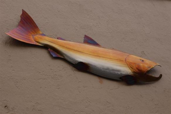 One of three salmon , decorating a wall downtown.