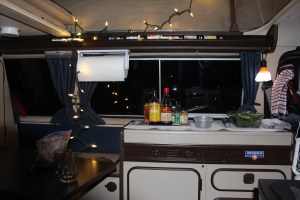 In the evening,cooking  dinner, surrounded by a string of little Christmas lights.